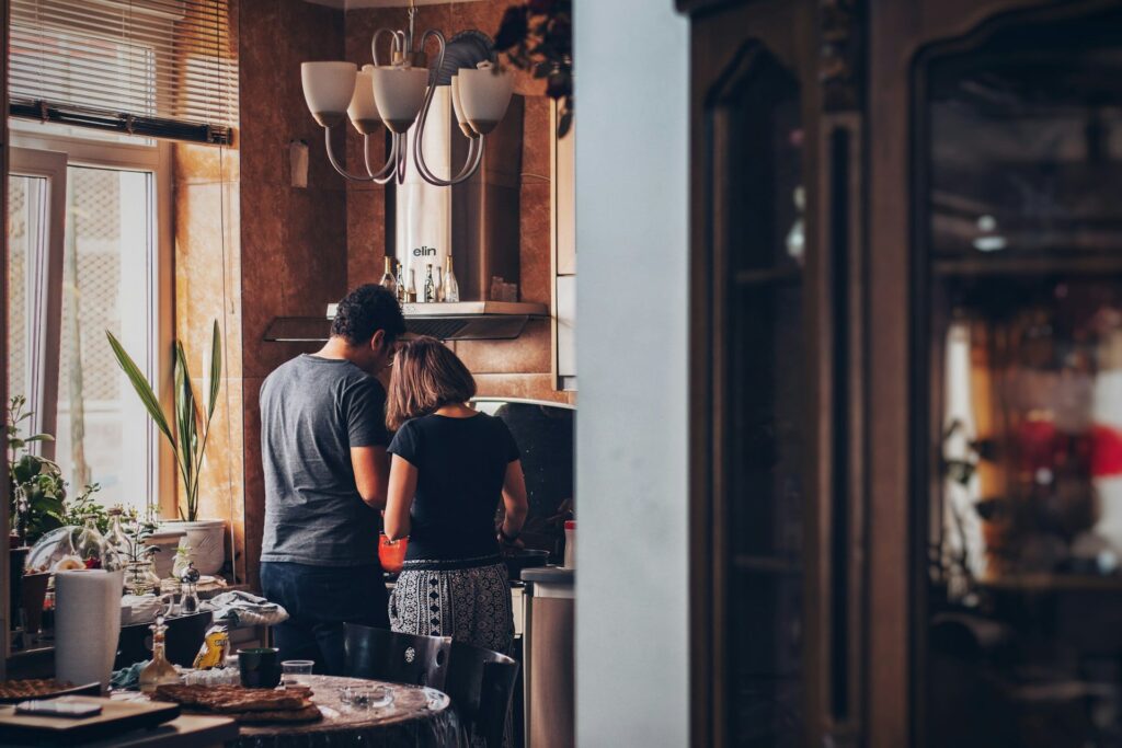Rückenaufnahme eines Paares beim Kochen in ihrer gemeinsamen Küche 