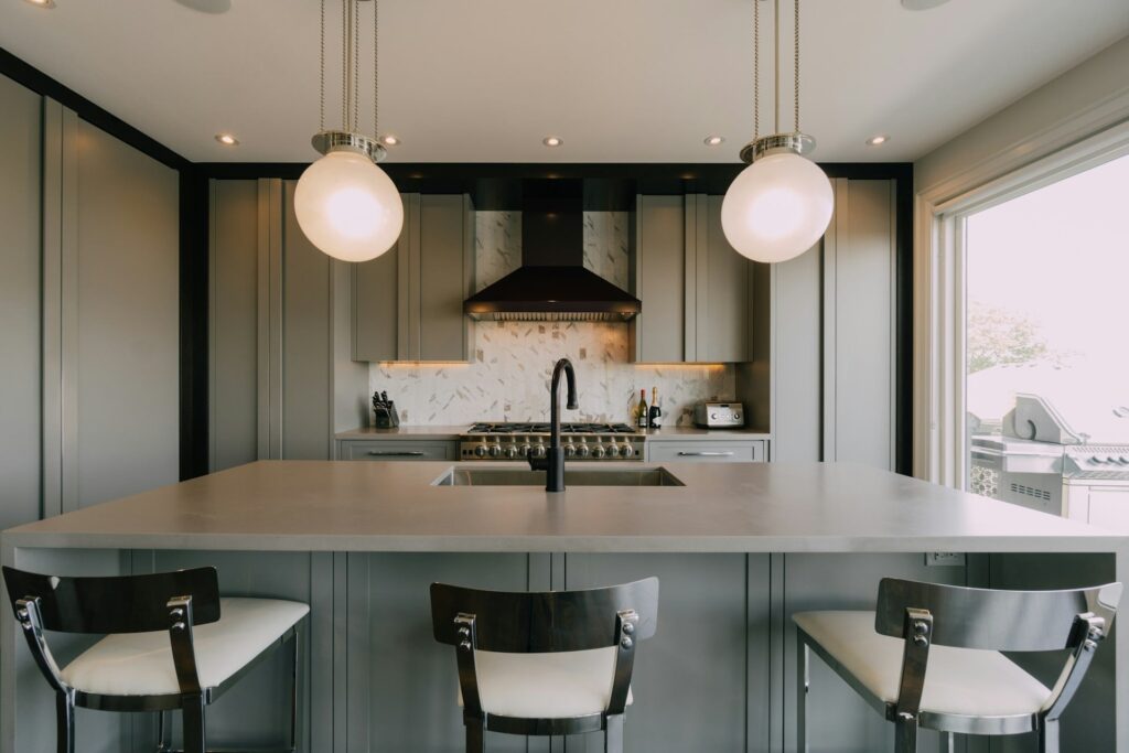 Helle Küche mit Mittelinsel und drei Barhockern, modernes Design in Holz und Weiß