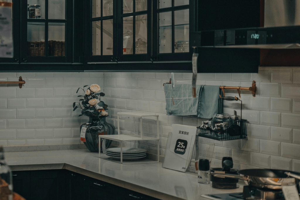 Elegante schwarze Rahmenfronten mit Glas in einer modernen Küche mit weißer Metrofliese und hellen Arbeitsflächen – ideal für stilvolle Küchenmodernisierung.