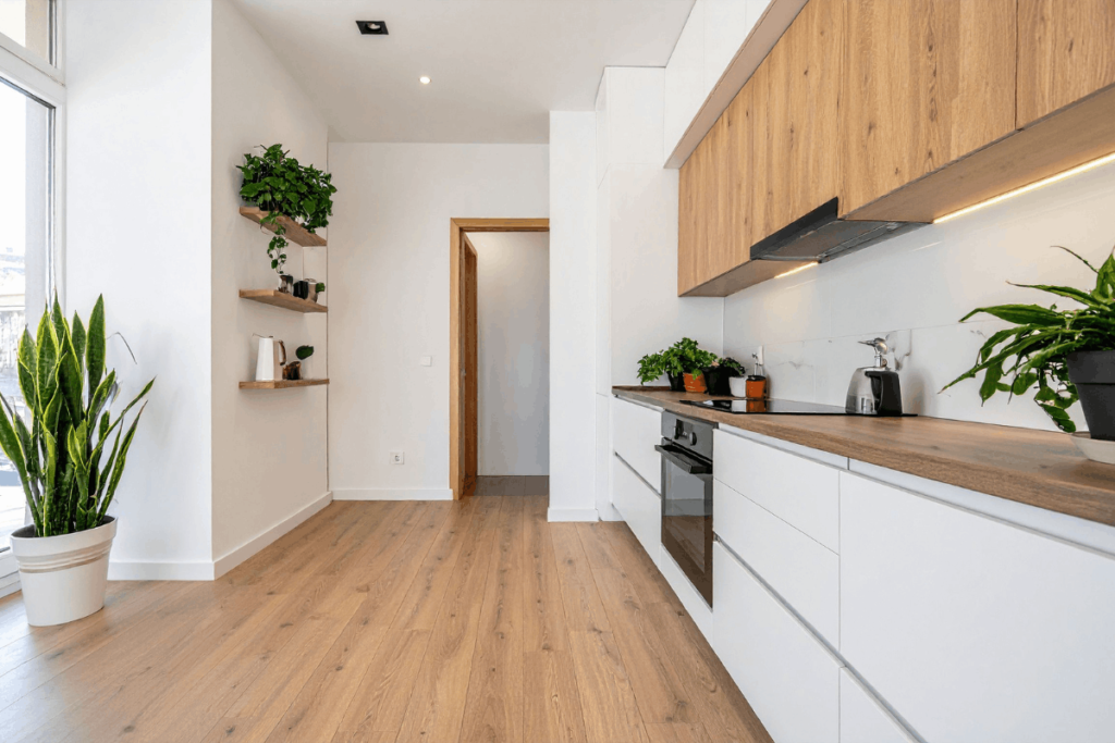 Holzküche in modernem Design mit weißen Fronten, Holzarbeitsplatte und viel Tageslicht
